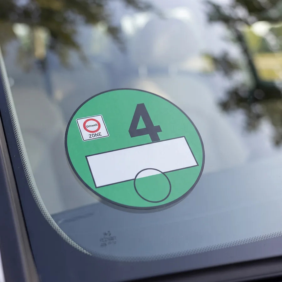 Grüne Umweltplakette der Schadstoffgruppe 4, von innen auf eine Windschutzscheibe geklebt